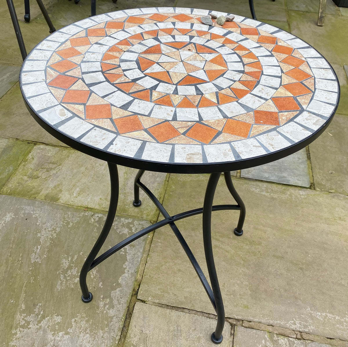 Round mosaic table with decorative pattern on a patio
