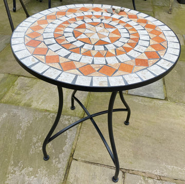 Round mosaic table with decorative pattern on a patio