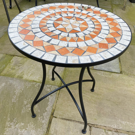 Round mosaic table with decorative pattern on a patio