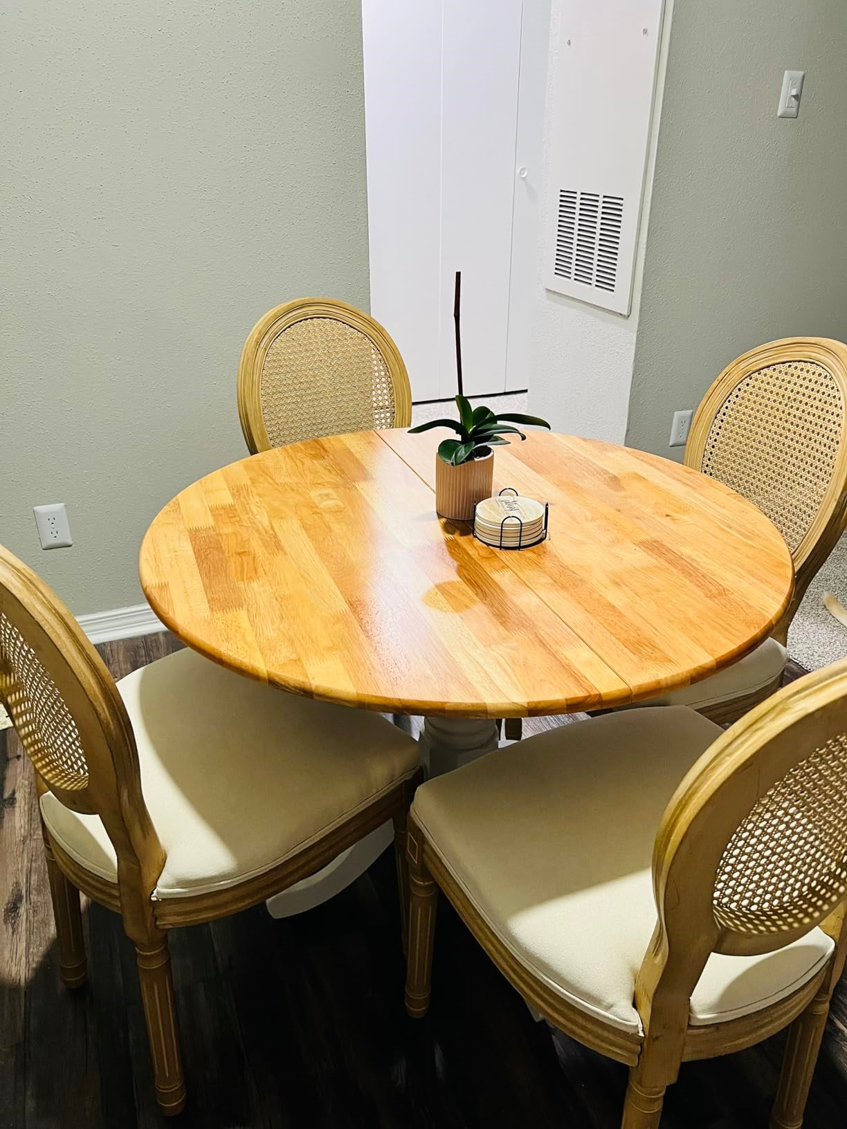 solid wood table in round shape with white pedestal legs