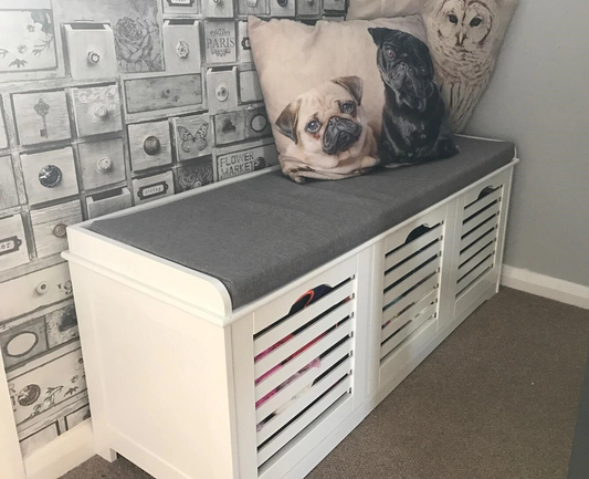 White hallway storage bench with grey cushion and three drawers